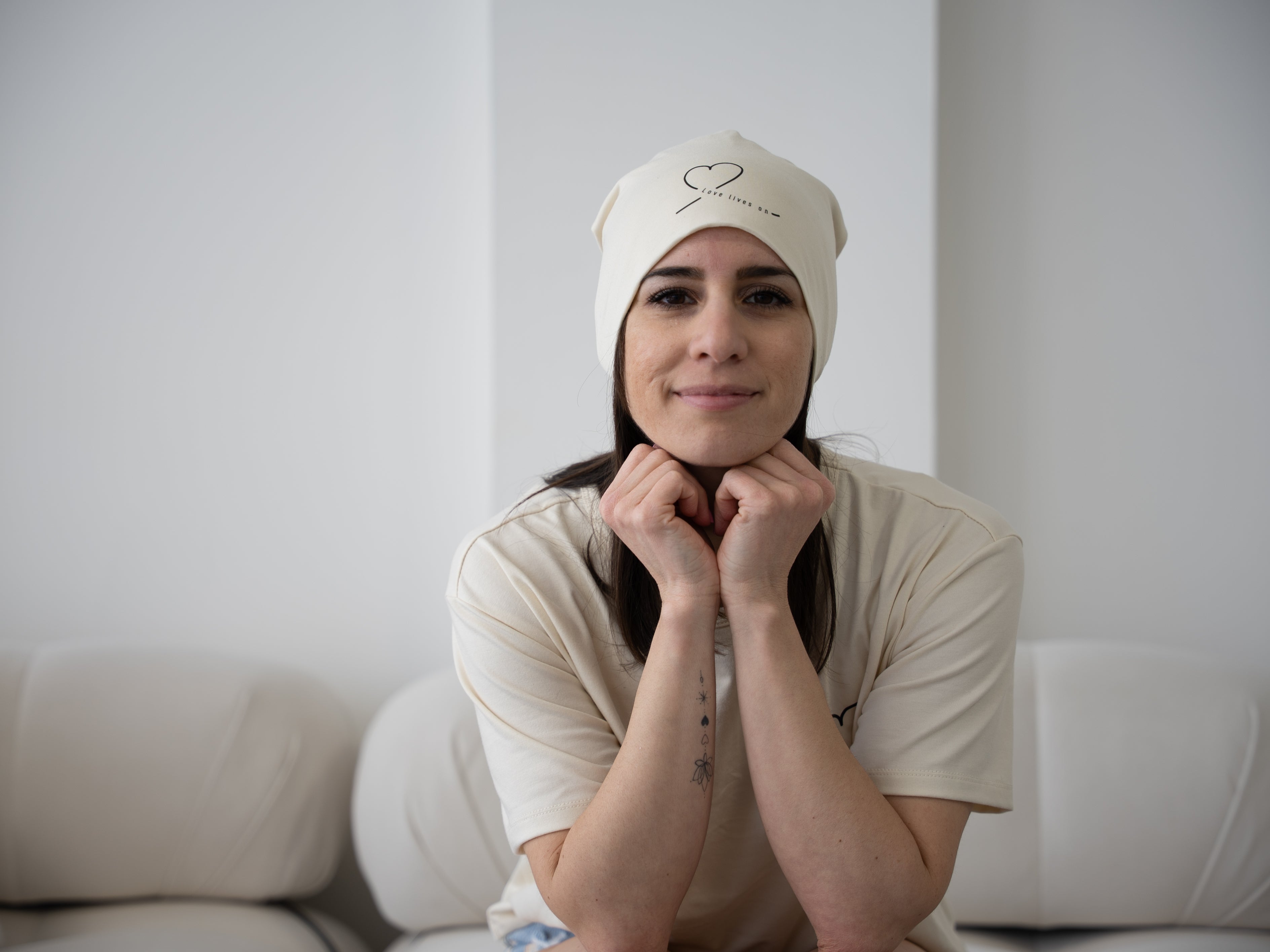 Model wearing the natural bamboo cotton beanie from HeartWear Co.’s Love Collection, embroidered with “Love Lives On.
