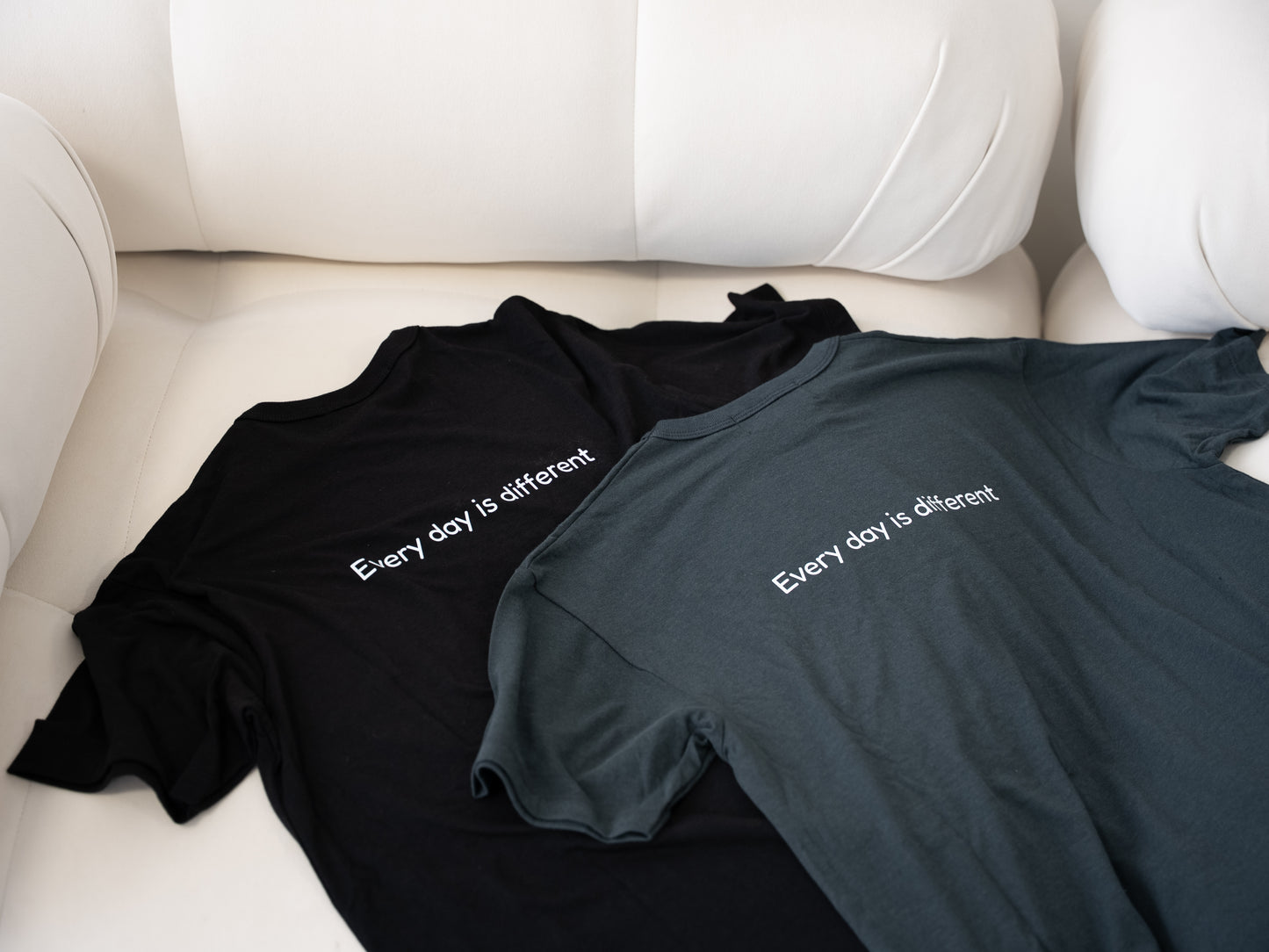 Men’s Healing T-shirts in black and gray lying flat on couch – soft and durable loungewear for men