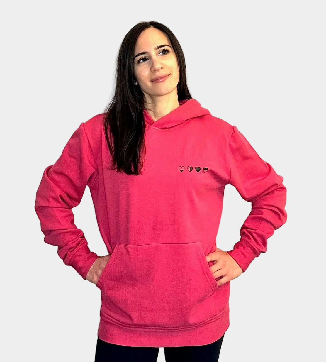 Person wearing a pink hoodie with a small logo on a white background