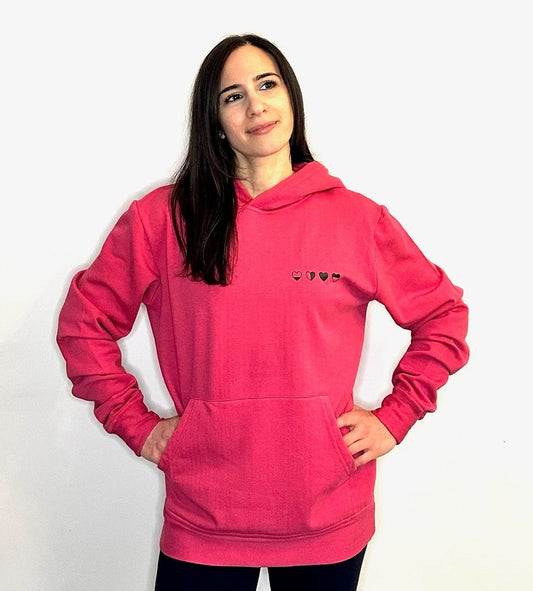 Person wearing a pink hoodie with a small logo on a white background