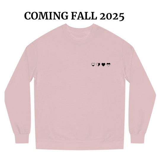 Light pink sweater with four black heart symbols representing emotional healing. Healing Hearts design by HeartWear Co.