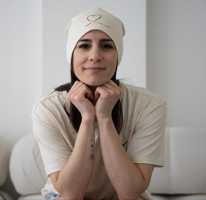Model wearing the natural bamboo cotton beanie from HeartWear Co.’s Love Collection, embroidered with “Love Lives On.